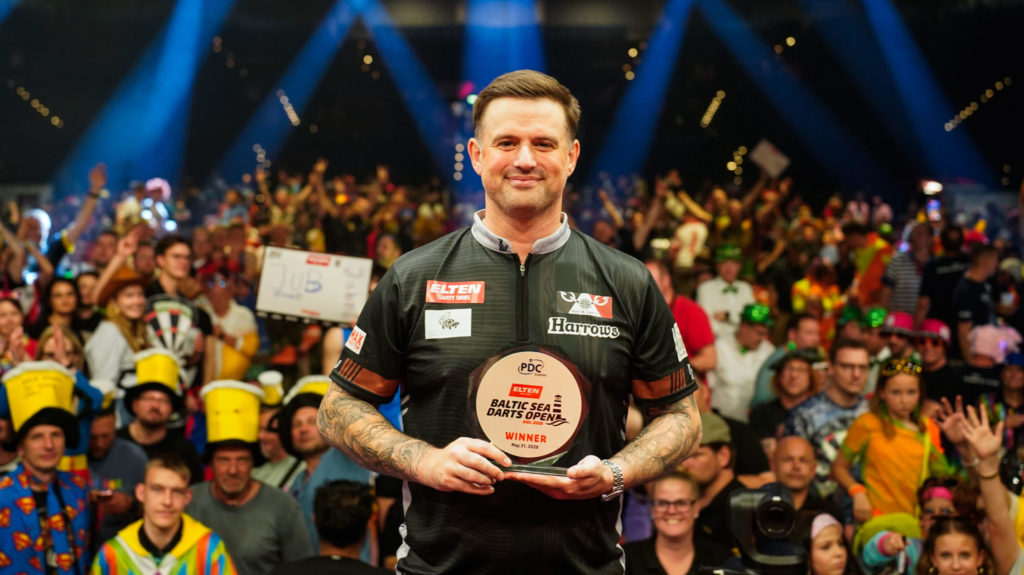 Luke Woodhouse posiert als glücklicher Sieger der ELTEN Safety Shoes Baltic Sea Darts Open 2026 vor jubelndem Publikum in Kiel