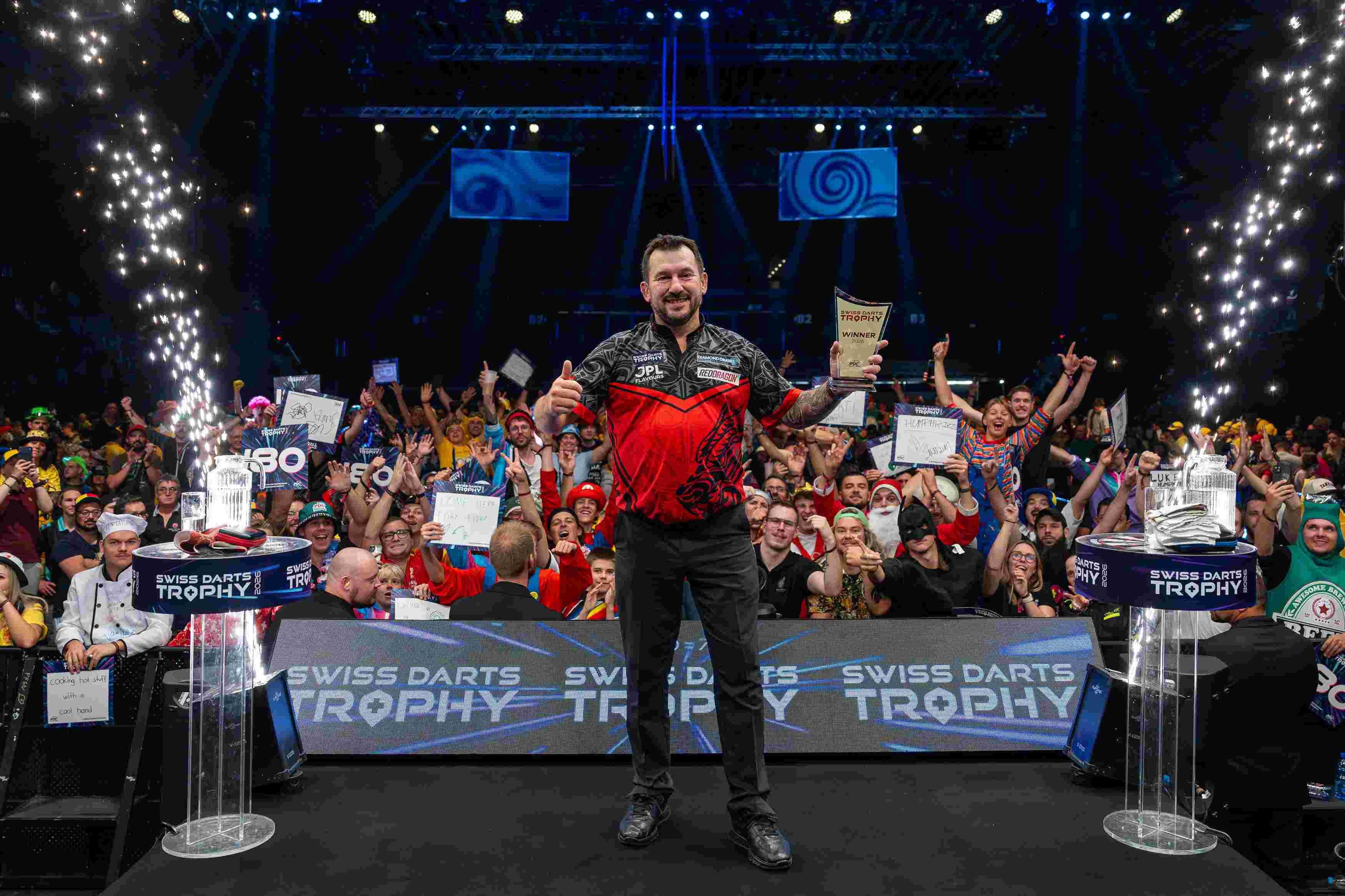 Jonny Clayton posiert als glücklicher Sieger der Swiss Darts Trophy 2026 vor jubelndem Publikum in Basel